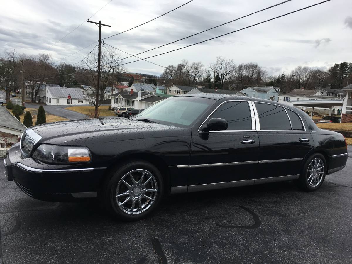 A black limo parked in the parking lot.